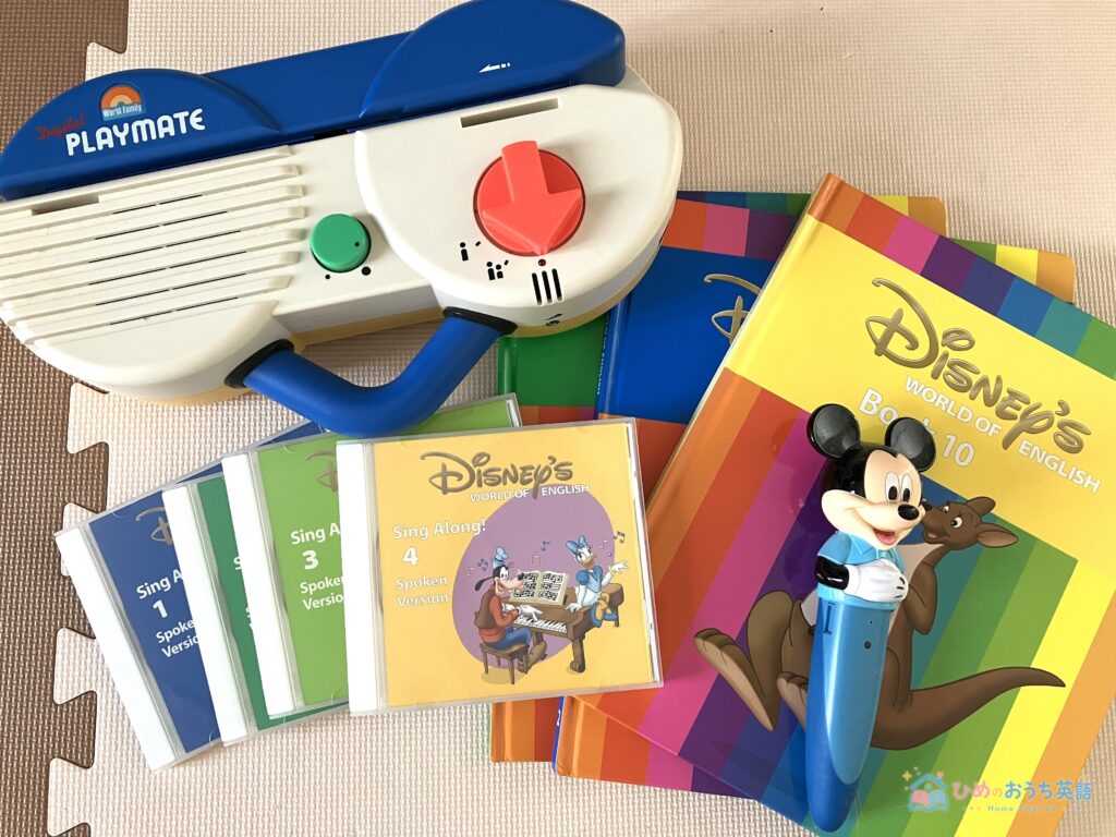 ディズニー英語システム(DWE)の教材一式。デジタルプレイメイト本体、Sing AlongのCD、Disney's World of Englishの絵本、ミッキーのマジックペンが並んだ実物写真