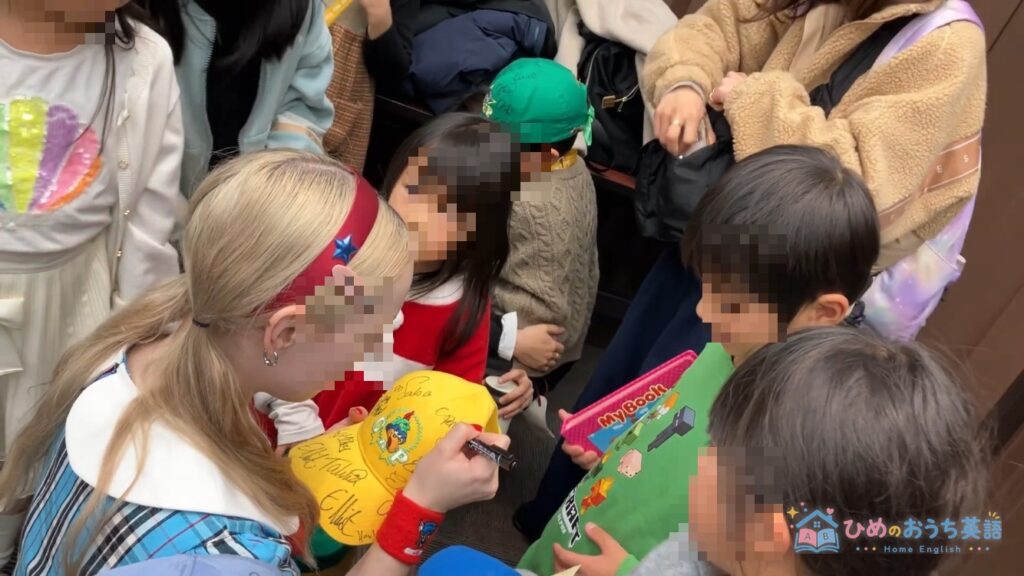 DWEのイベントでキャストに帽子へサインをもらう子どもたち(顔はモザイク処理)
